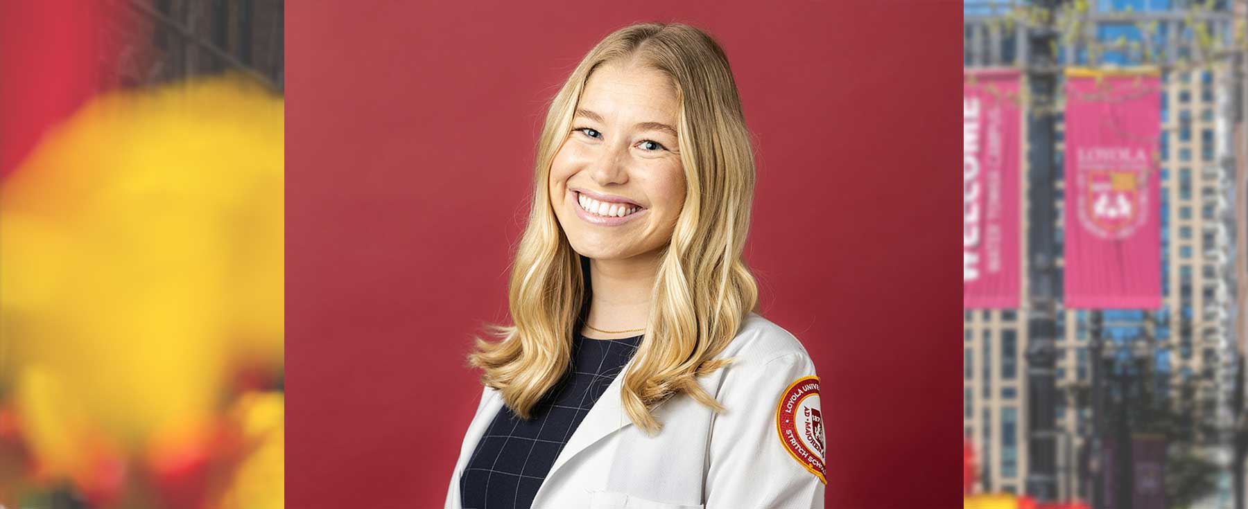 Charlotte Adema wearing white lab coat in front of a maroon background